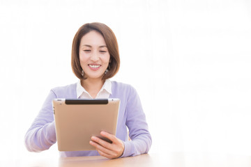 タブレットPCを見る女性