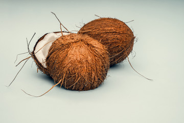 Parts of coconut on a colored background. Close up. Fresh ripe coconut broken into pieces.