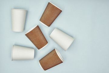 Paper cup in hand on a colored background. Eco-friendly materials in a coffee shop, biodegradable disposable tableware. Close up.