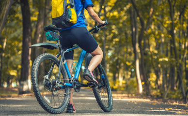 woman cyclist rides mountain bike forest trails.