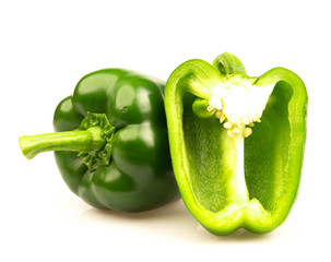 Whole and cut green bell peppers on white background