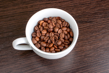 Roasted coffee beans in a cup background. International coffee day concept.