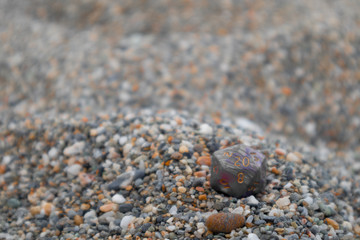 Grey Purple Pink Dungeon and Dragons dice with character sheets at the beach