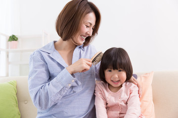 Obraz na płótnie Canvas 娘の髪を梳かす母
