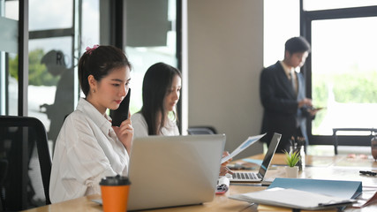 A comfortable business workspace is surrounding by a happy employee and various office stuff.