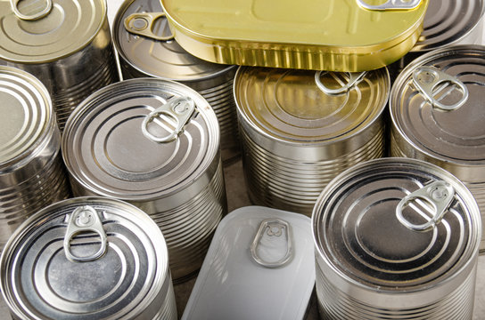 Set of various canned foods in tin cans on kitchen table, non-perishable, long shelf life food for survival in emergency conditions concept