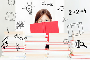 Fototapeta premium Young cute girl sitting at the table and reading a book