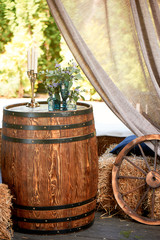 An old wooden barrel with floral decor.Photo zone for a photo shoot in the village style.