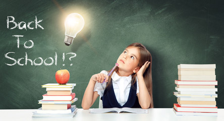 Young cute girl at chalkboard with light bulb over head