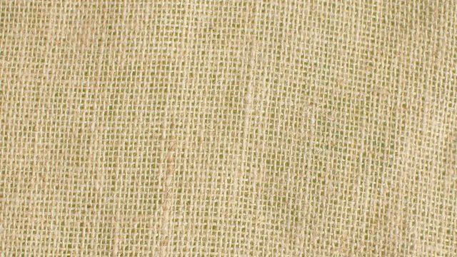 Extreme close up - coarse burlap of rare weave. . Texture, textile background. Macro shooting, camera slowly moving along the cloth on slider