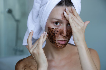 DIY Coffee scrub face mask. Beauty skin care. Portrait of young woman with coffee scrub on her...