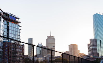 Beautiful sunset background of downtown Boston showing the Prudential Center and other notable skyscrapers in the city with sun flares and glows in the bg.