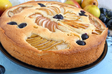 Delicious autumn pie with pear slices and grapes. Close-up