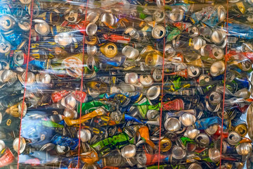 Abstract background of colorful compressed aluminium cans in container stored for recycling. Concept of recycling, ecology, environmental pollution