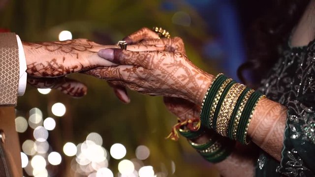  A moment of togetherness, marked by intricate henna designs and gentle hands, symbolizing love and commitment.