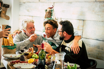 Happy family men enjoy together christmas lunch at home - mixed agesd generations people eat and have fun together celebrating holidays - father son grandfather together