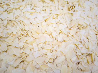 Obraz premium Almond shavings close up. Lots of nuts in the market. Healthy organic food concept. Nut flakes, petals.