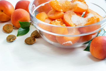 Ripe fresh sliced apricots in glass bowl, prepared for cooking homemade jam.