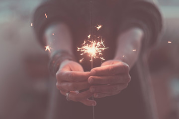 Romantic love concept of life with close up of hands with fire sparklers by night to celebrate -...
