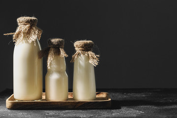 Glass bottles of milk with sackcloth caps