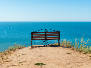 bench on a hill overlooking the sea on a sunny day