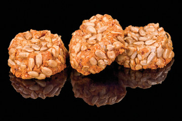 Delicious balls with sunflower seeds, isolated on black background, with reflection