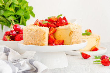 Cottage cheese grated casserole with crumb and fresh strawberries on top on a white plate on a light wooden background. Traditional Russian cake. Horizontal, copy space.
