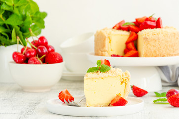 Cottage cheese grated casserole with crumb and fresh strawberries on top on a white plate on a light wooden background. Traditional Russian cake. Horizontal, copy space.