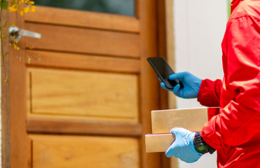 A man in a red shirt holding a box in hand stands at the customer's door to deliver the parcel to the customer.