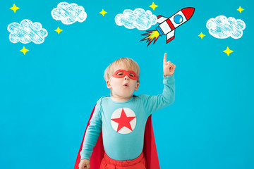 Portrait of superhero child against blue background