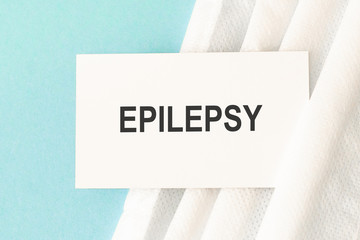 Word epilepsy with medical mask on a blue background. Medicine concept