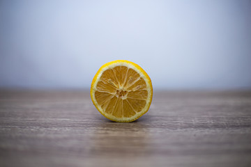 General plan A sliced lemon stands on a wooden table with the pulp in the lens