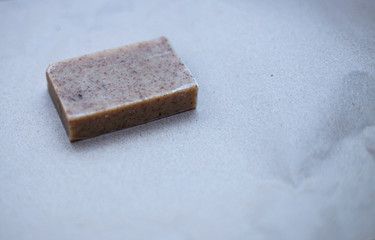 Brown men's beard soap with coffee scrub in the corner of the frame lies on kraft paper
