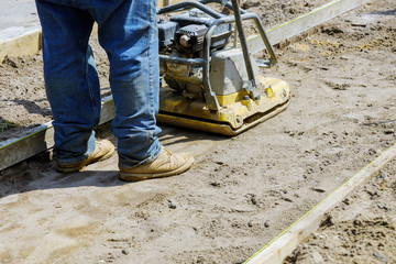 Vibrating hammer, with sand jumping in process in the during sidewalk