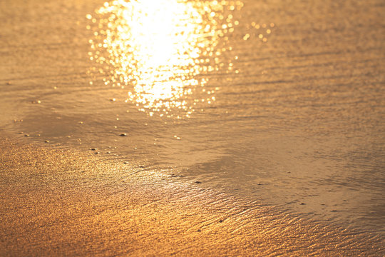 Wet golden sand on the sunset, abstract texture