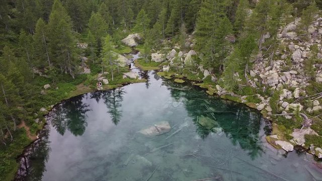 Italy  Piedmont,  Devero village  , ( lago delle streghe )  Alps - caucasian girl do trekking , hiking in a wood mountains, 
Lake of witches  with clear water in a wild landscape of nature