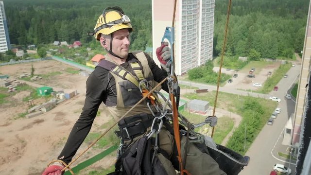 Steeplejacking. Professional rope access technician works outside the building