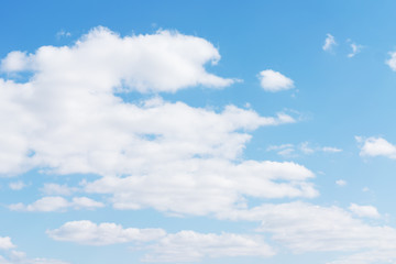 Naklejka na ściany i meble White cumulus clouds against the background against blue on a blue background.