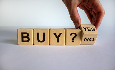 Time to buy. Hand turns a cube and changes the word 'no' to 'yes'. Beautiful white background. Business concept. Copy space.