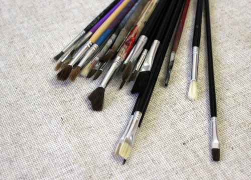 Artistic equipment paint brushes on linen fabric