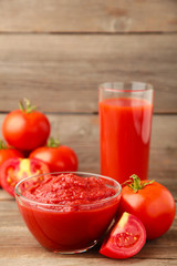 Fresh tomatoes with paste and juice on grey background