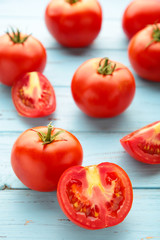 Ripe red tomatoes on a blue wooden background. Vertical foto