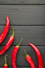 Red Hot chili peppers on black wooden background, closeup