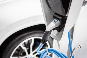 The power supply plugged into an electric car to charging a battery at the charging station	
