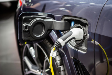 The power supply plugged into an electric car to charging a battery at the charging station	
