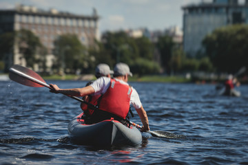 A process of kayaking in the city river canals, with colorful canoe kayak boat paddling, process of canoeing, group of kayaks