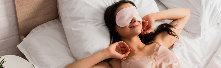 panoramic concept of young woman in eye mask lying on bed