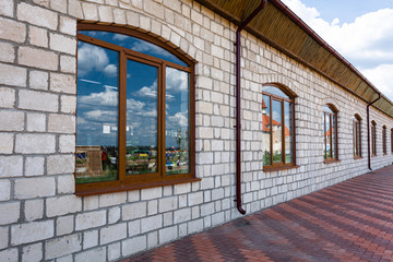 Colored red paving slabs and brown pvc metal-plastic windows. Construction of the park.