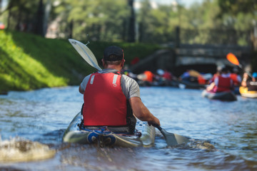 A process of kayaking in the city river canals, with colorful canoe kayak boat paddling, process of canoeing, group of kayaks