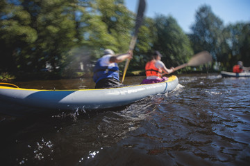 Naklejka premium A process of kayaking in the city river canals, with colorful canoe kayak boat paddling, process of canoeing, group of kayaks